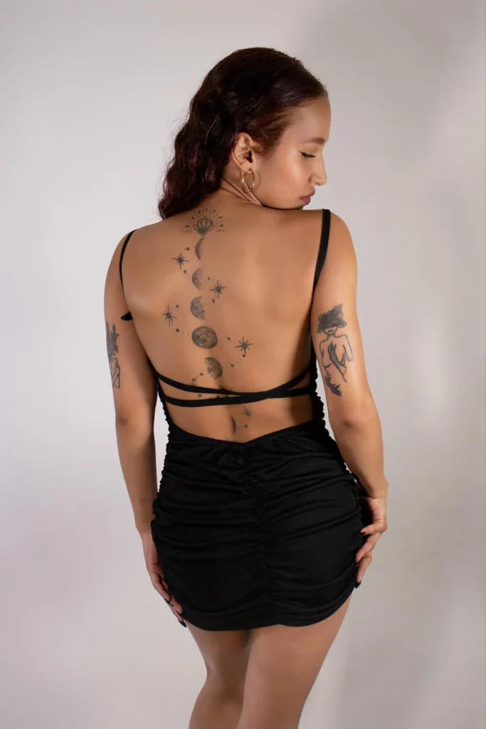 CaseyCalderon is showing off her full moon tattoo on her back