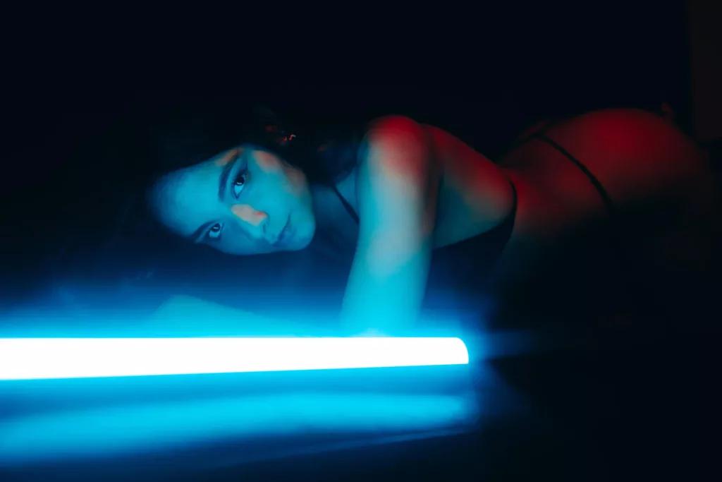 ScarlettHottie69 is a full black background lit by a florescent light showing her beauty