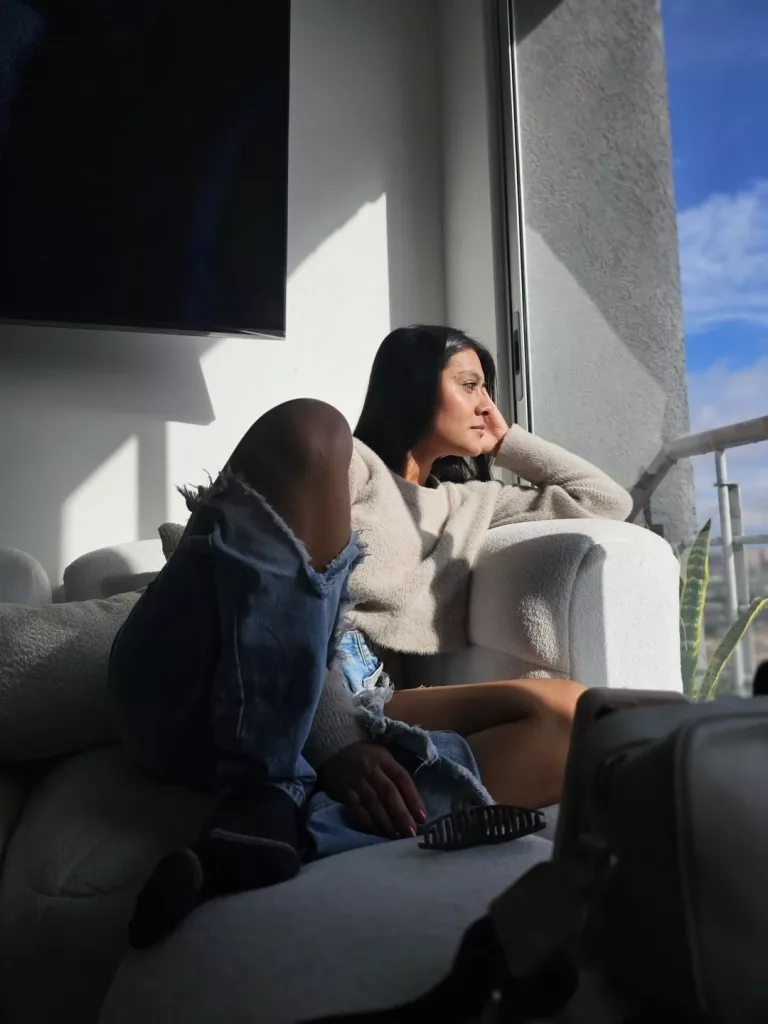 ThaliaAres sitting on the couch looking out