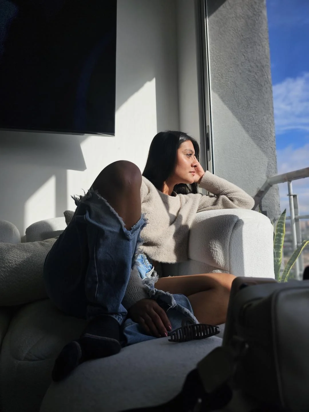 ThaliaAres sitting on the couch looking out
