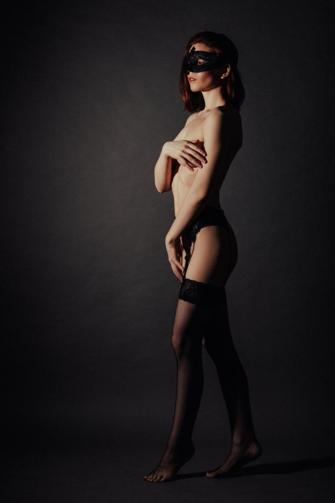 cam model in a dark room with stocking on nude