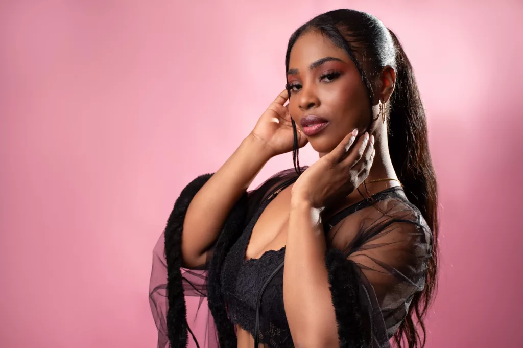 ZendayaRosse in sheer black top, sunlit pose, ebony cam