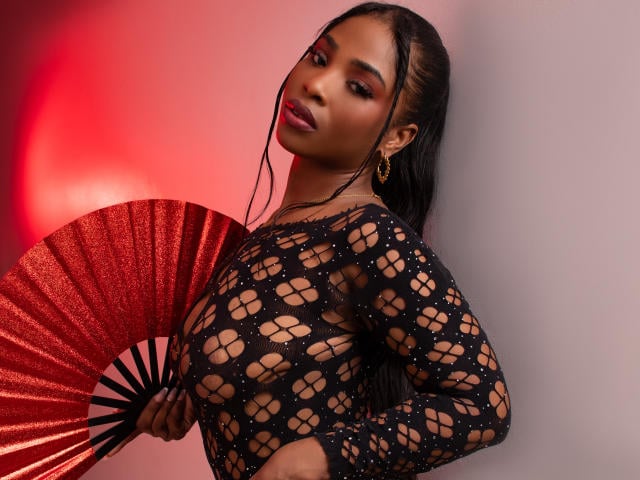 ZendayaRosse holds red fan, fishnet top look ebony