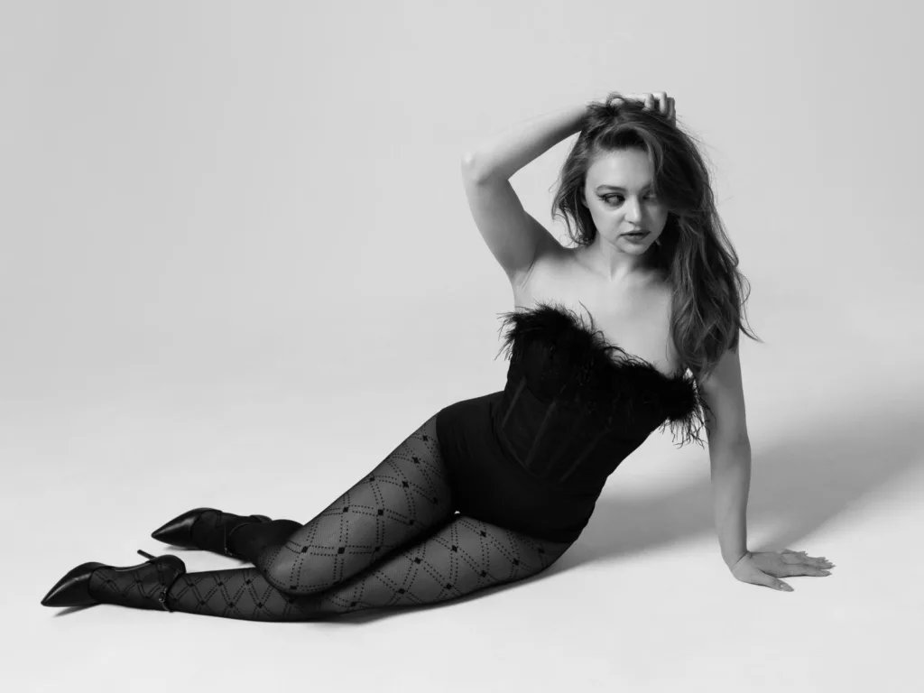 MayxFlower in black strapless dress, polka-dot tights, monochrome.