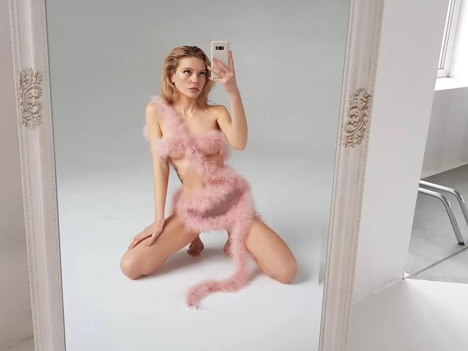 EolantaMarina in pink fur outfit, kneeling, snapping a mirror selfie with camera.
