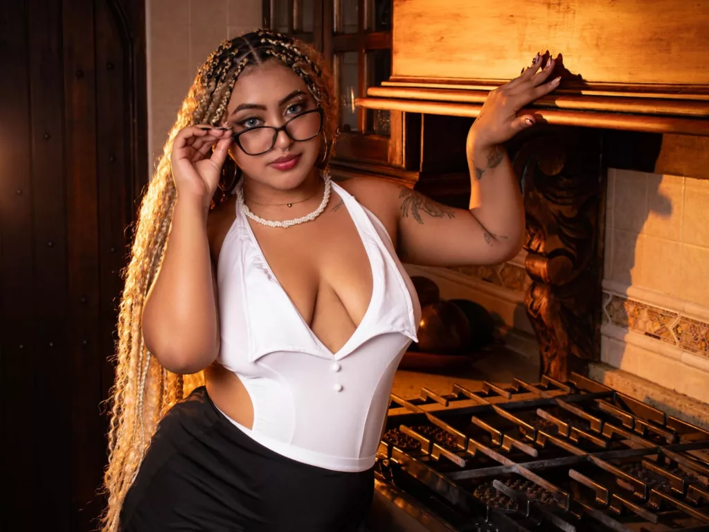 BBW ebony Latina LuisaCameron in deep V-neck top, black pants, and glasses