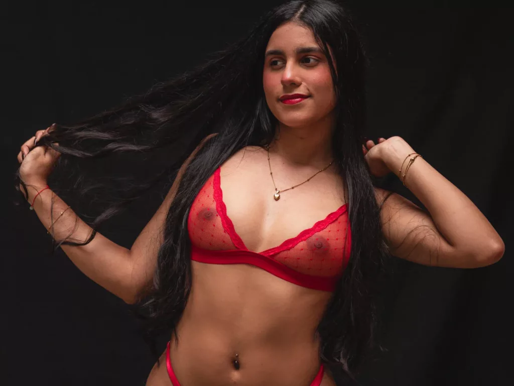 TiffanyRose in red mesh bra, belly piercing, sultry smile, ideal for double dildo tease.