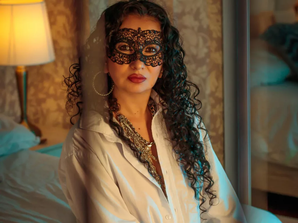 SamanthaAntolin in black lace mask, topless, gold jewelry, warm lighting