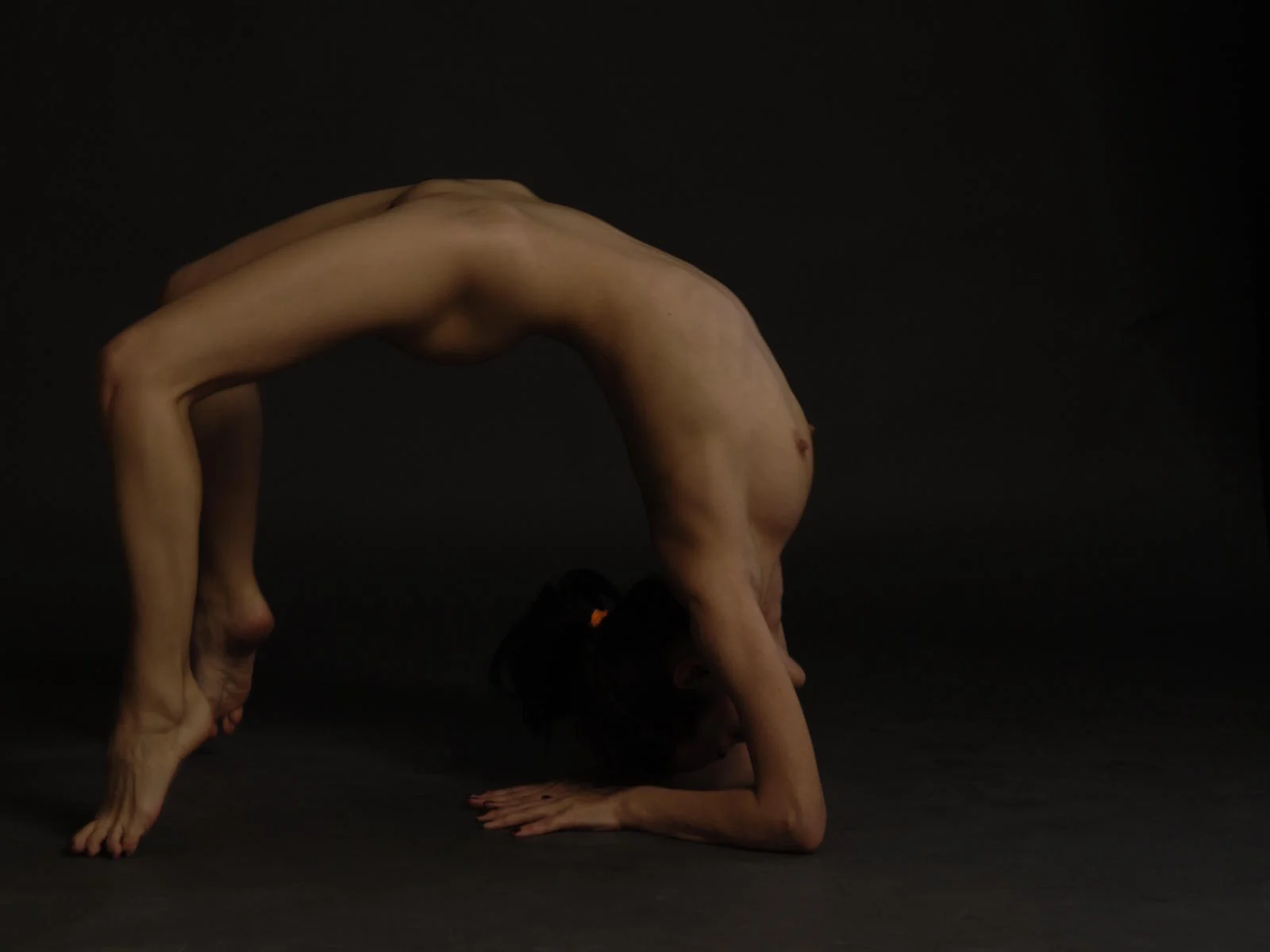Kamilove, a flexible camgirl, performing an impressive artistic backbend bridge pose.