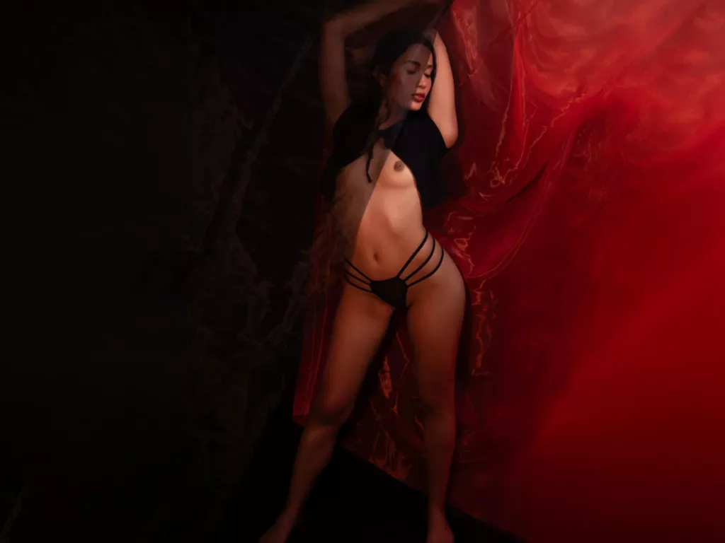 JennTylor’s Voyeur Desire shines in a red draped, sensual pose.
