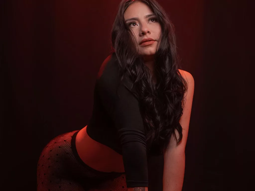 Thick Latina Sexy RoseAnna in a black top and fishnet stockings.