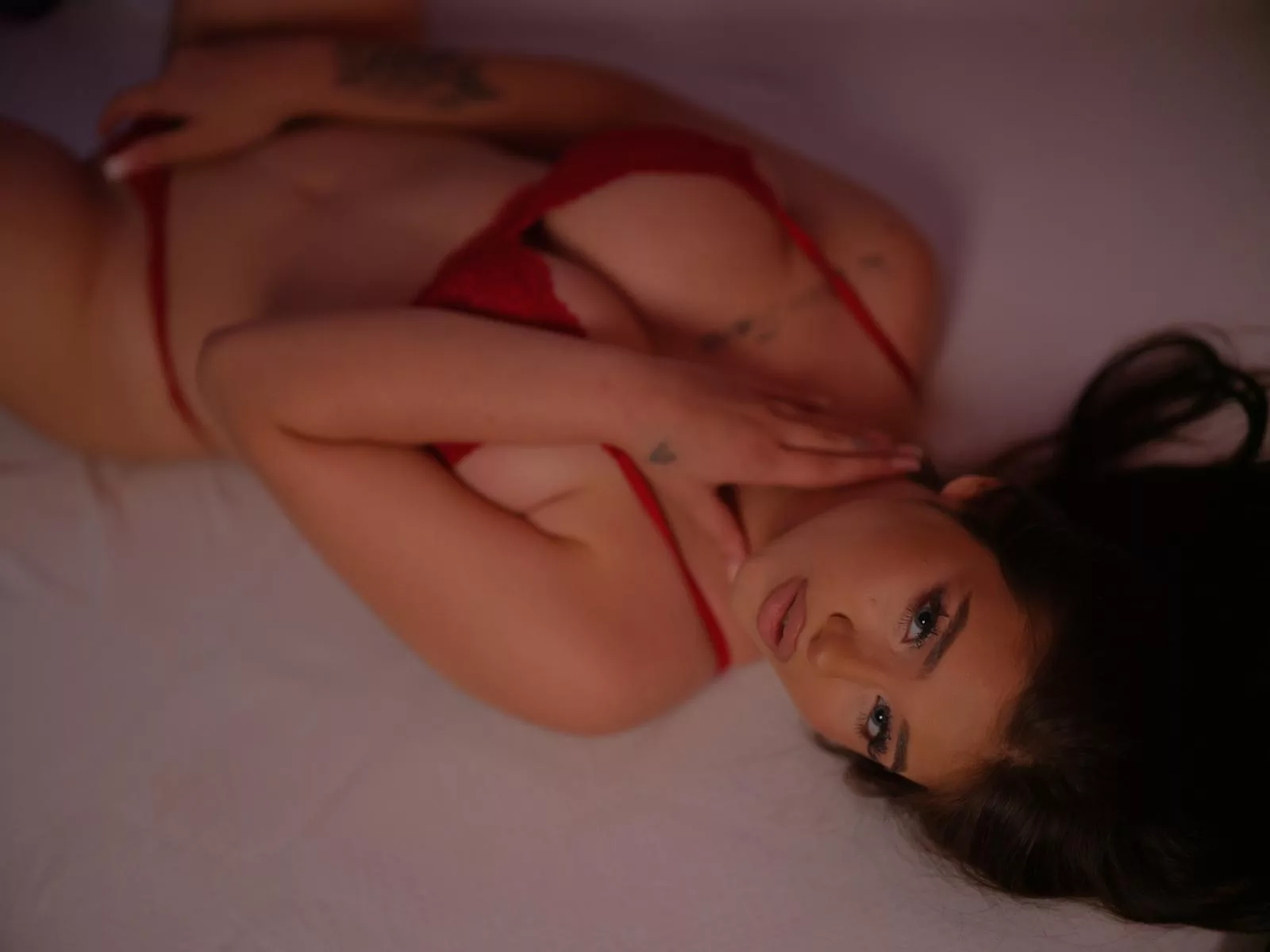 SkylaMoor, the Sex.Cam Virgin, lounges in red lace, exuding confidence.