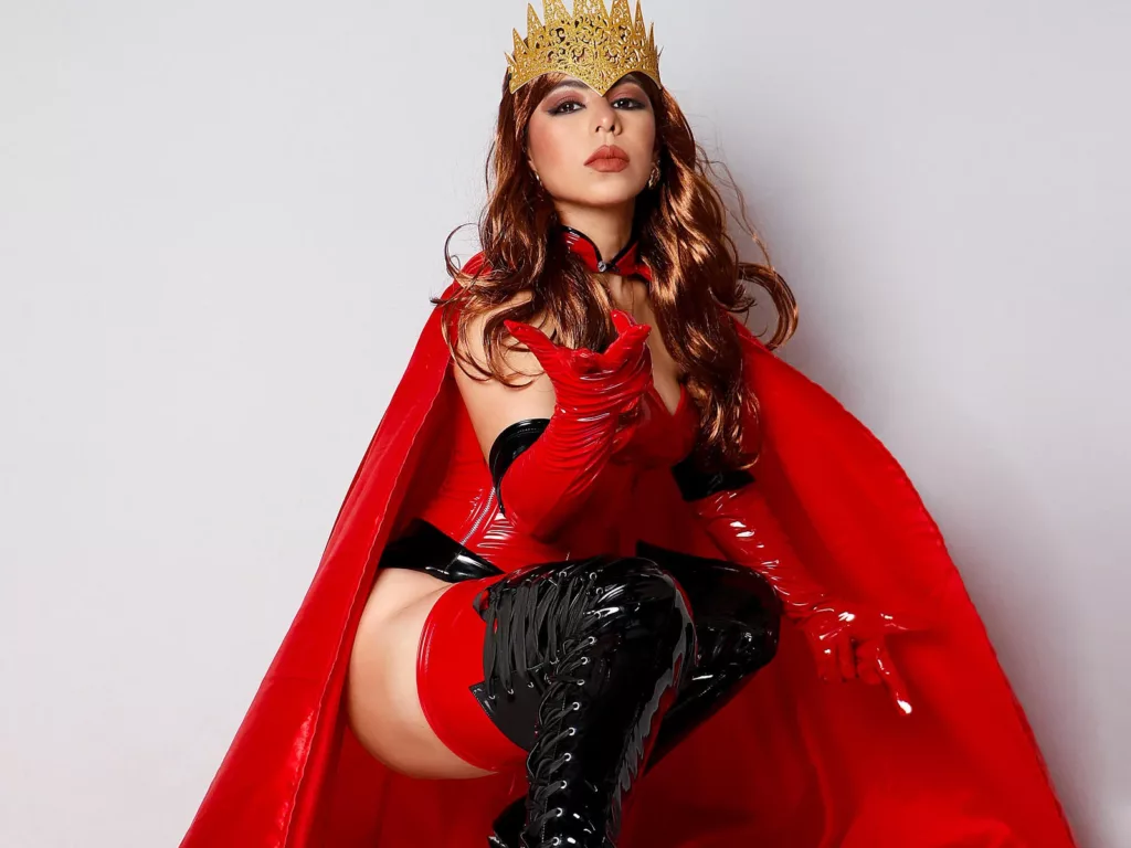 Femdom Mistress NicolBennett wearing a gold crown and red cape.